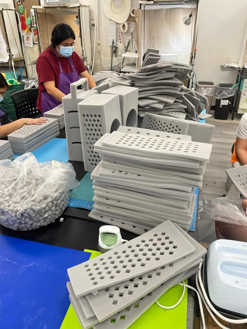 Employees assemble graterhead hats at Foam Party Hats' facility in Houston.