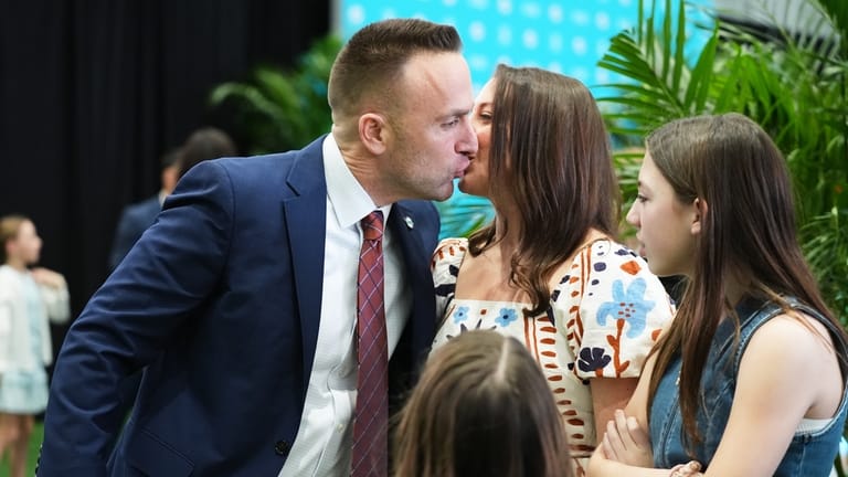 Miami Dolphins head coach Jeff Hafley, left, kisses his wife...