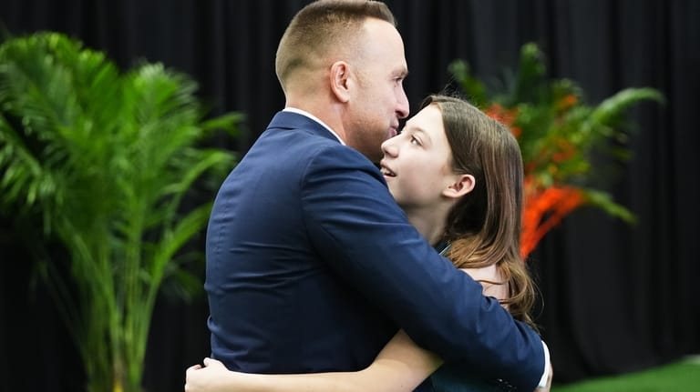 Miami Dolphins head coach Jeff Hafley, left, hugs his daughter...
