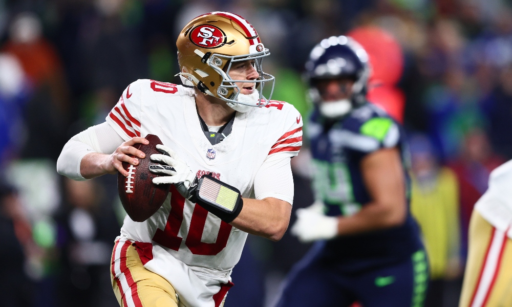 San Francisco 49ers quarterback Mac Jones rolls out to pass against the Seattle Seahawks