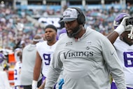 Minnesota Vikings defensive line coach Marcus Dixon walks the sideline wearing a "Salute to...