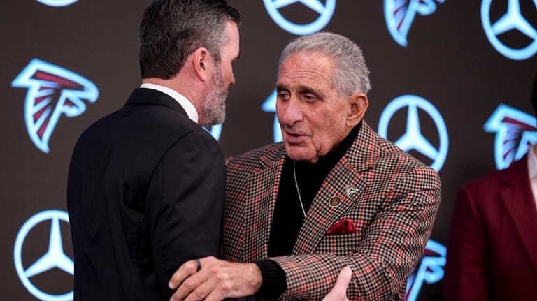 Atlanta Falcons head coach Kevin Stefanski embraces team owner Arthur...