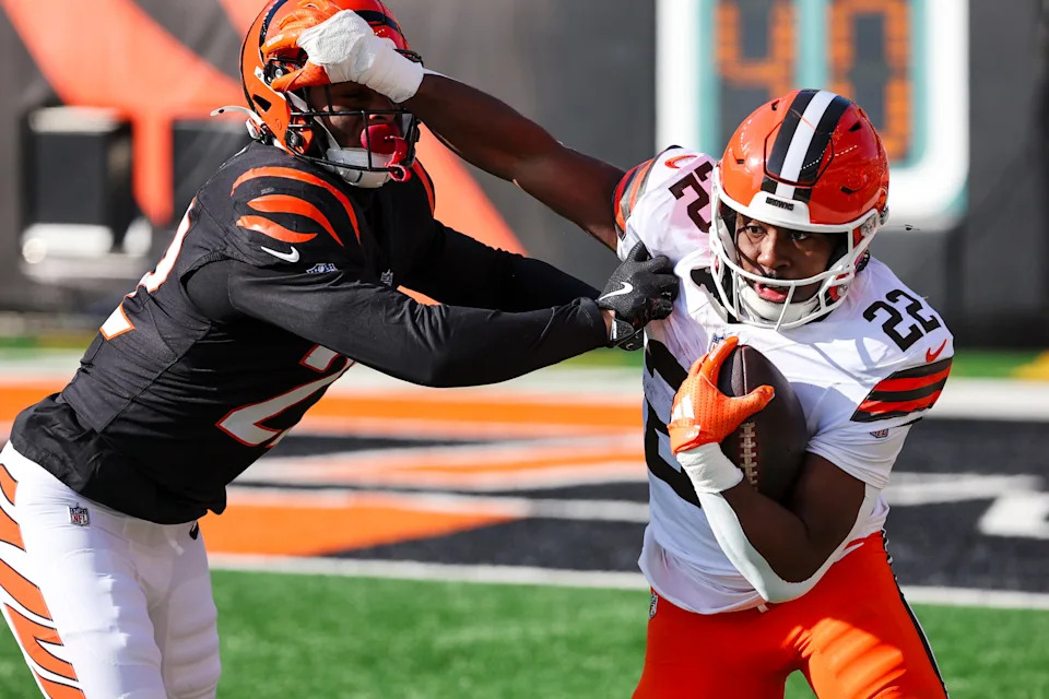 Jan 4, 2026; Cincinnati, Ohio, USA; Cincinnati Bengals safety Geno Stone (22, left) tackles Cleveland Browns running back Dylan Sampson (22, right) following a reception by Sampson during the first quarter at Paycor Stadium. Mandatory Credit: Joseph Maiorana-Imagn Images