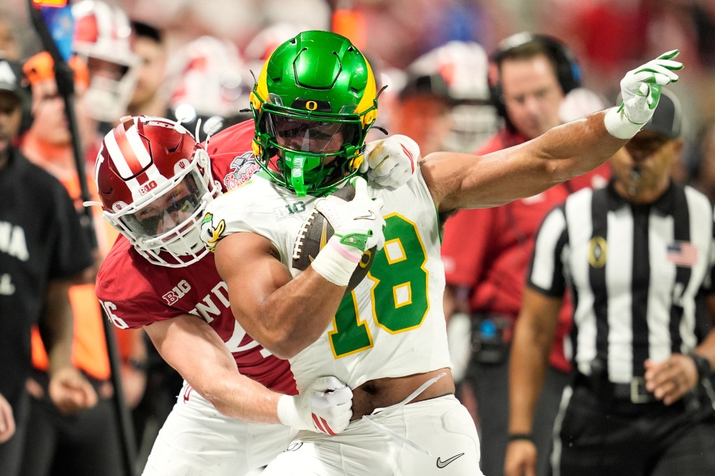 Oregon Ducks tight end Kenyon Sadiq (18) runs against Indiana Hoosiers linebacker Isaiah Jones (46)during the first quarter of the 2025 Peach Bowl and semifinal game of the College Football Playoff at Mercedes-Benz Stadium. 