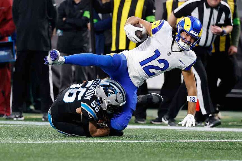 Los Angeles Rams wide receiver Puka Nacua (12) is tackled by Carolina Panthers linebacker Christian Rozeboom (56) during the first half of an NFL wild-card playoff football game, Saturday, Jan. 10, 2026, in Charlotte, N.C. (AP Photo/Rusty Jones)