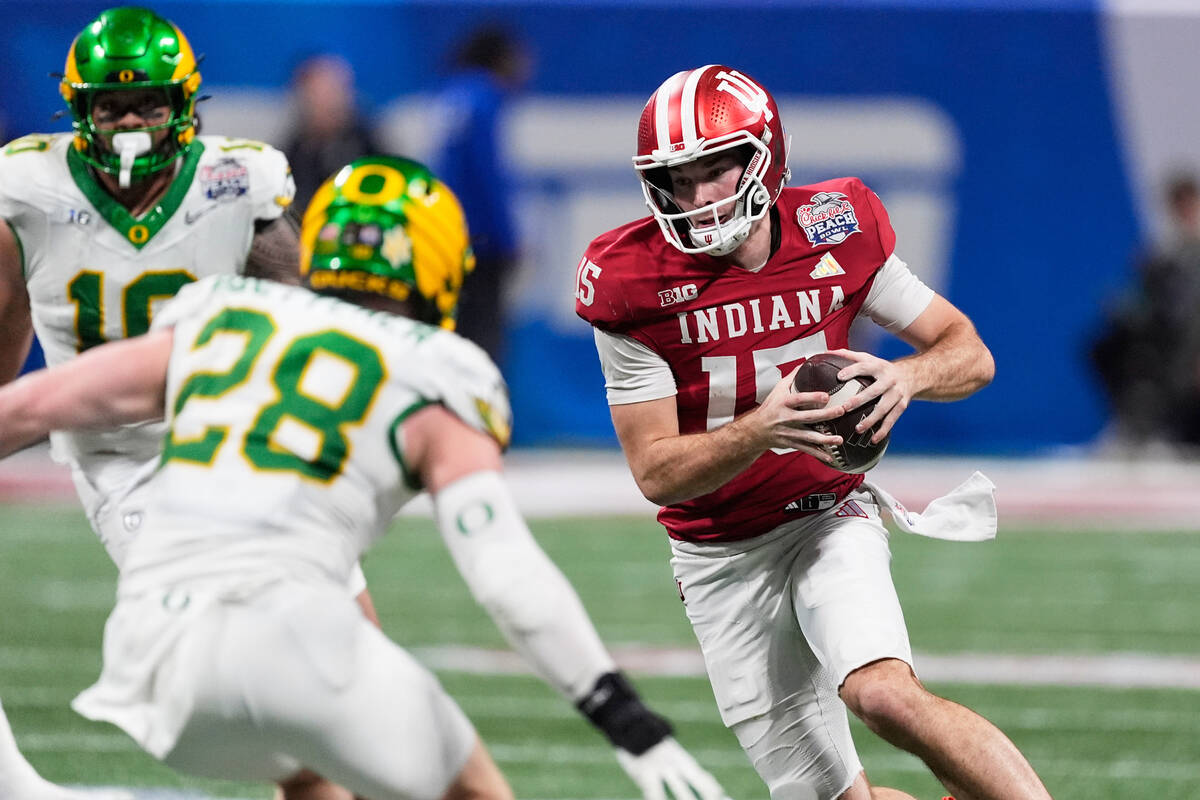 Indiana quarterback Fernando Mendoza (15) carries against Oregon linebacker Bryce Boettcher (28 ...