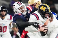 West quarterback Brady Cook of Missouri (12) is sacked by East defensive lineman Tonka...