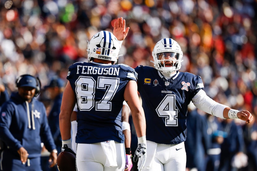 Dallas Cowboys quarterback Dak Prescott (4) celebrates with tight end Jake Ferguson (87)...