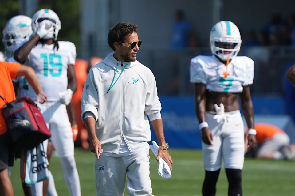 Miami Dolphins coach Mike McDaniels talks with the wide receivers during joint practice with the Detroit Lions at the Lions headquarters and training facility in Allen Park, Thursday, Aug. 14, 2025.