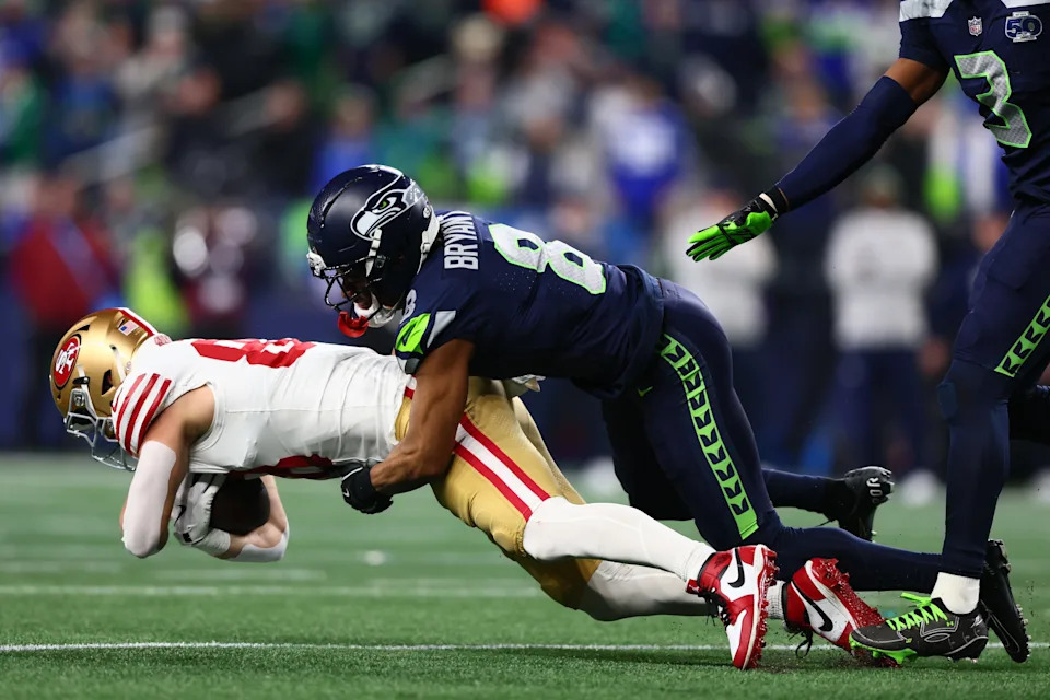 San Francisco 49ers tight end Jake Tonges is tackled by Seattle Seahawks safety Coby Bryant.