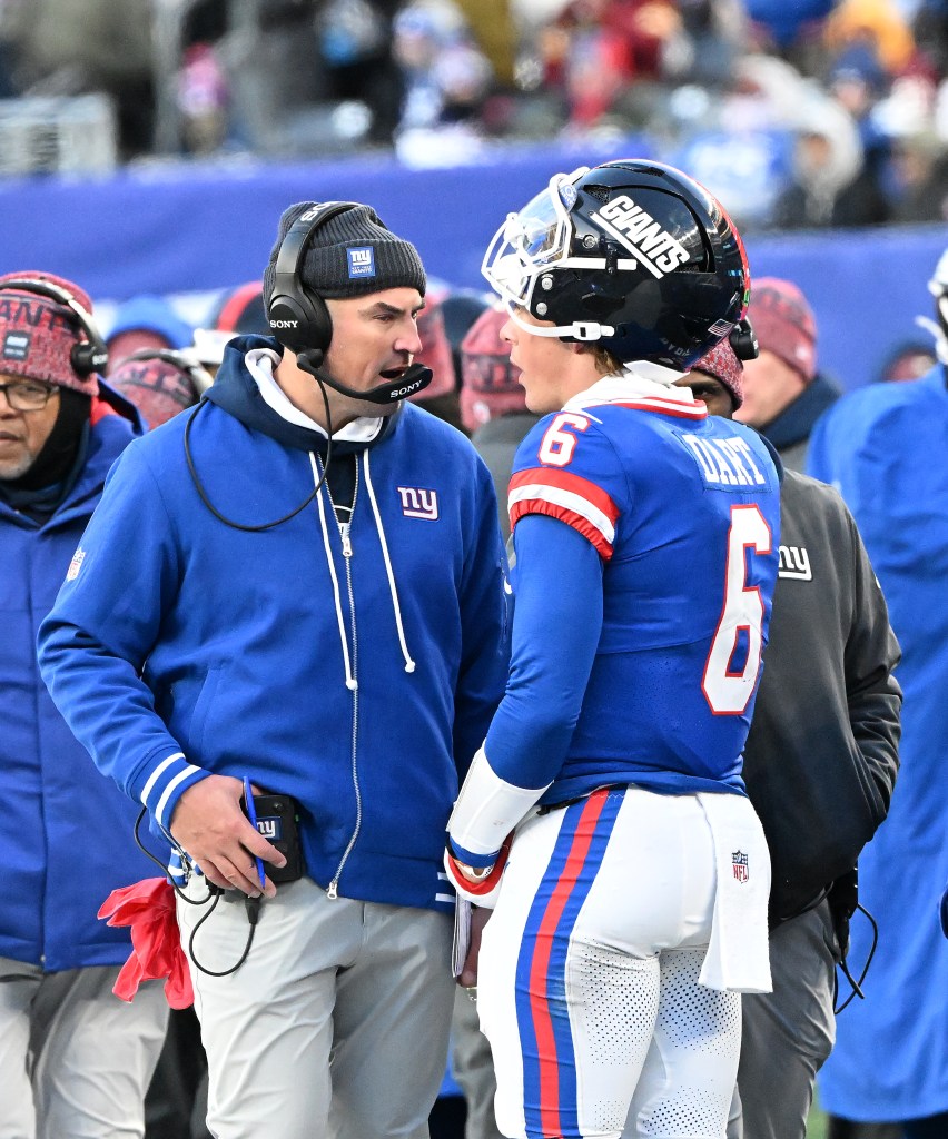 New York Giants head coach Mike Kafka speaking with quarterback Jaxson Dart during a football game.