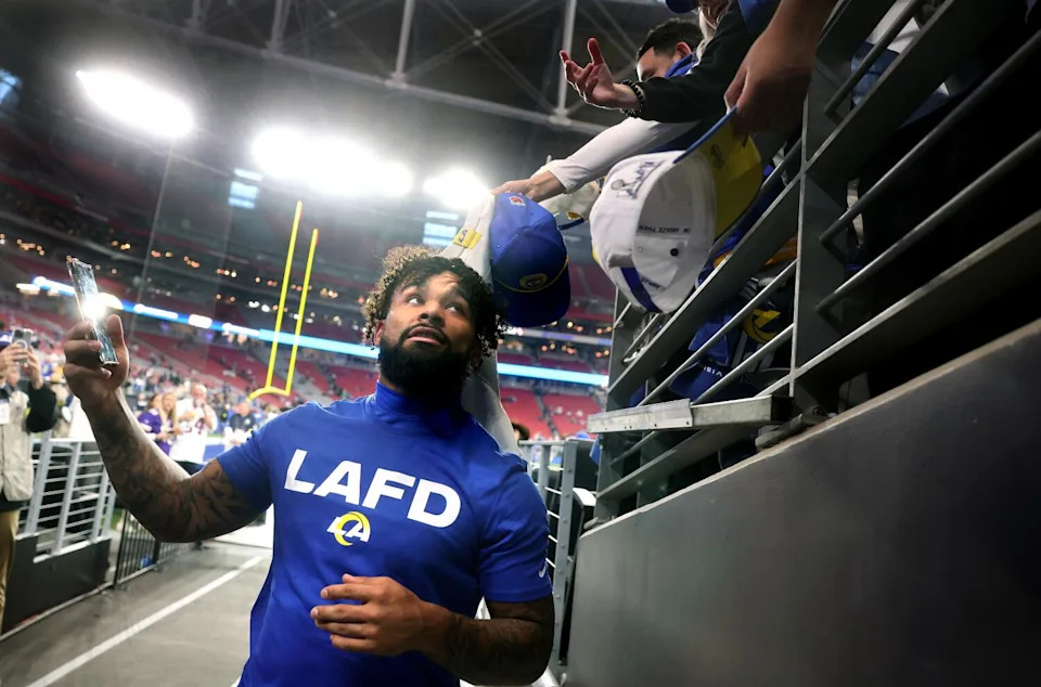 Rams running back Kyren Williams takes a selfie for a fan before a playoff game against the Minnesota Vikings.