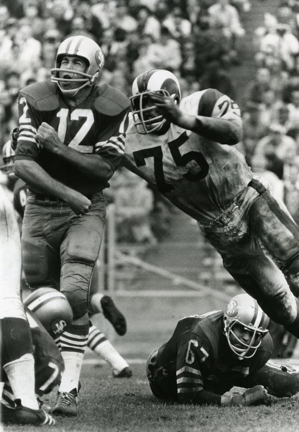 Los Angeles Rams defensive end Deacon Jones hits San Francisco 49ers quarterback John Brodie.