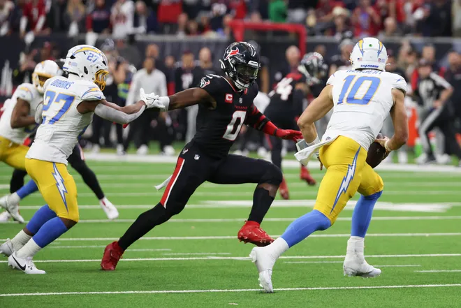 Jan 11, 2025; Houston, Texas, USA; Los Angeles Chargers quarterback Justin Herbert (10) scrambles from Houston Texans linebacker Azeez Al-Shaair (0) in the second quarter in an AFC wild card game at NRG Stadium. Mandatory Credit: Thomas Shea-Imagn Images