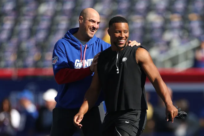 EAST RUTHERFORD, NEW JERSEY - OCTOBER 20: Offensive coordinator Mike Kafka of the New York Giants hugs Saquon Barkley #26 of the Philadelphia Eagles prior to the game at MetLife Stadium on October 20, 2024 in East Rutherford, New Jersey. (Photo by Luke Hales/Getty Images)