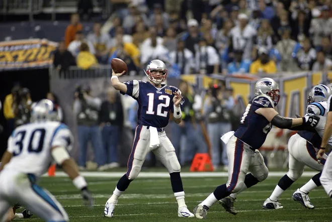 Feb 1, 2004; Houston, TX, USA; FILE PHOTO; New England Patriots quarterback Tom Brady (12) throws a pass against the Carolina Panthers during Super Bowl XXXVIII at Reliant Stadium. The Patriots defeated the Panthers 32-29.