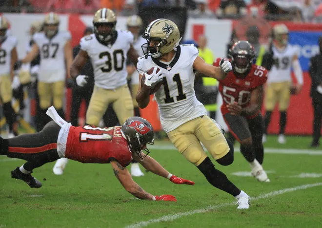 Dec 7, 2025; Tampa, Florida, USA; New Orleans Saints wide receiver Dante Pettis (11) runs for a gain past Tampa Bay Buccaneers wide receiver Ryan Miller (81) during the second quarter at Raymond James Stadium. Mandatory Credit: Kim Klement Neitzel-Imagn Images
