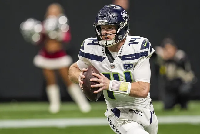 Dec 7, 2025; Atlanta, Georgia, USA; Seattle Seahawks quarterback Sam Darnold (14) rolls out against the Atlanta Falcons during the game at Mercedes-Benz Stadium.