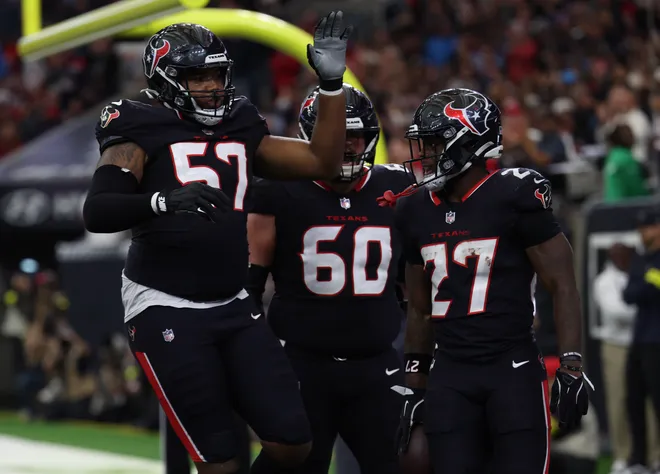 Dec 14, 2025; Houston, Texas, USA; Houston Texans running back Woody Marks (27), offensive tackle Blake Fisher (57) and center Jake Andrews (60) celebrate a touchdown during the first quarter against the Arizona Cardinals at NRG Stadium. Mandatory Credit: Thomas Shea-Imagn Images