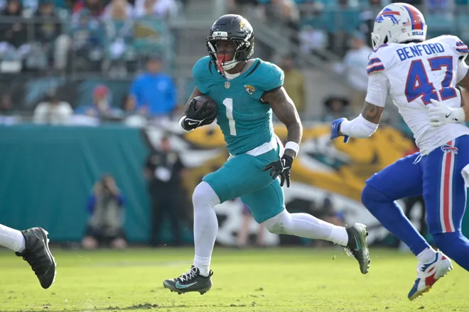 Jan 11, 2026; Jacksonville, FL, USA; Jacksonville Jaguars running back Travis Etienne Jr. (1) runs with the ball during the second half against the Buffalo Bills in an AFC Wild Card Round game at EverBank Stadium. Mandatory Credit: Melina Myers-Imagn Images