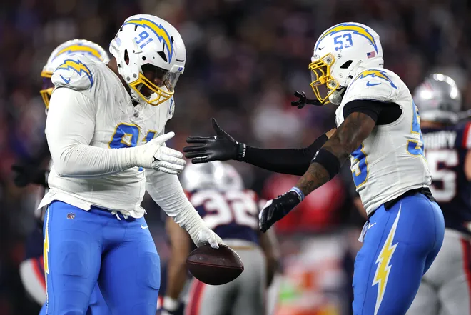 FOXBOROUGH, MASSACHUSETTS - JANUARY 11: Da'shawn Hand #91 of the Los Angeles Chargers celebrates with teammate Del'shawn Phillips #53 after a fumble recovery against the New England Patriots during the third quarter of the AFC Wild Card Playoff game at Gillette Stadium on January 11, 2026 in Foxborough, Massachusetts. (Photo by Sarah Stier/Getty Images)