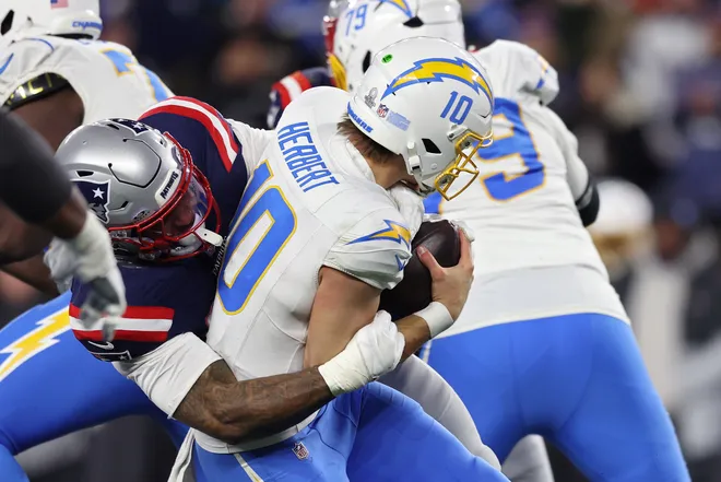 FOXBOROUGH, MASSACHUSETTS - JANUARY 11: Anfernee Jennings #33 of the New England Patriots sacks Justin Herbert #10 of the Los Angeles Chargers during the fourth quarter of the AFC Wild Card Playoff game at Gillette Stadium on January 11, 2026 in Foxborough, Massachusetts. (Photo by Adam Glanzman/Getty Images)