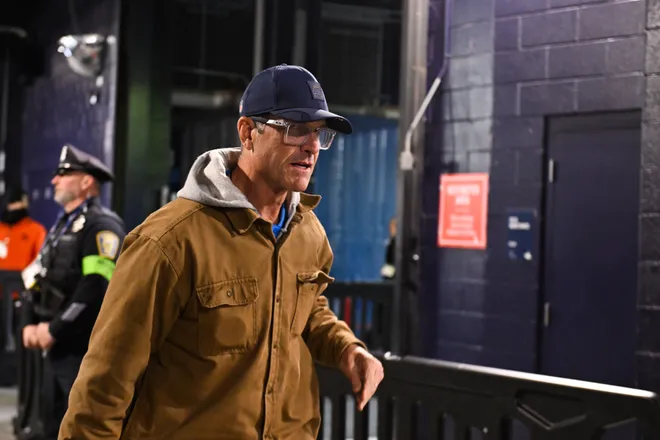 Jan 11, 2026; Foxborough, MA, USA; Los Angeles Chargers head coach Jim Harbaugh arrives for the game against the New England Patriots in an AFC Wild Card Round game at Gillette Stadium. Mandatory Credit: Eric Canha-Imagn Images