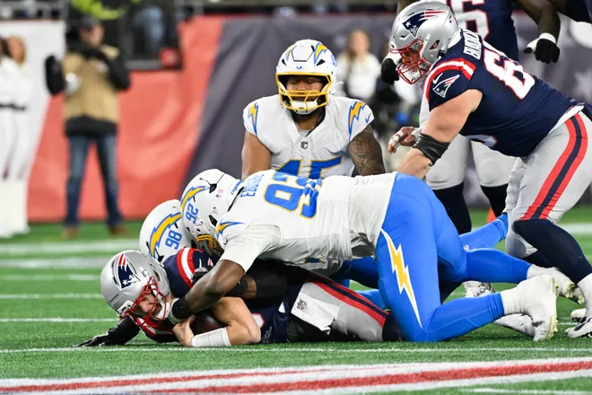 Jan 11, 2026; Foxborough, MA, USA; Los Angeles Chargers linebacker Odafe Oweh (98) and Los Angeles Chargers defensive tackle Justin Eboigbe (92) sack New England Patriots quarterback Drake Maye (10) during the first quarter in an AFC Wild Card Round game at Gillette Stadium. Mandatory Credit: Eric Canha-Imagn Images