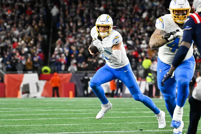 Jan 11, 2026; Foxborough, MA, USA; Los Angeles Chargers quarterback Justin Herbert (10) scrambles during the first quarter against the New England Patriots in an AFC Wild Card Round game at Gillette Stadium. Mandatory Credit: Eric Canha-Imagn Images