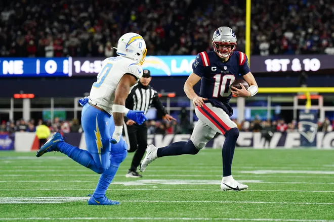 Jan 11, 2026; Foxborough, MA, USA; New England Patriots quarterback Drake Maye (10) scrambles as Los Angeles Chargers linebacker Daiyan Henley (0) defends during the second quarter in an AFC Wild Card Round game at Gillette Stadium. Mandatory Credit: David Butler II-Imagn Images