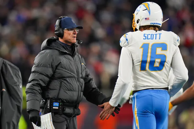 Jan 11, 2026; Foxborough, MA, USA; Los Angeles Chargers head coach Jim Harbaugh high fives Los Angeles Chargers punter JK Scott (16) during the second quarter against the New England Patriots in an AFC Wild Card Round game at Gillette Stadium. Mandatory Credit: David Butler II-Imagn Images