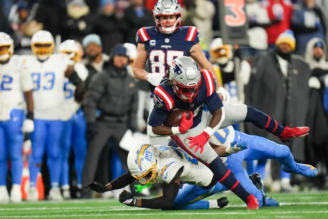 Jan 11, 2026; Foxborough, MA, USA; New England Patriots running back Rhamondre Stevenson (38) makes a catch and is tackled by Los Angeles Chargers cornerback Cam Hart (20) during the third quarter in an AFC Wild Card Round game at Gillette Stadium. Mandatory Credit: David Butler II-Imagn Images