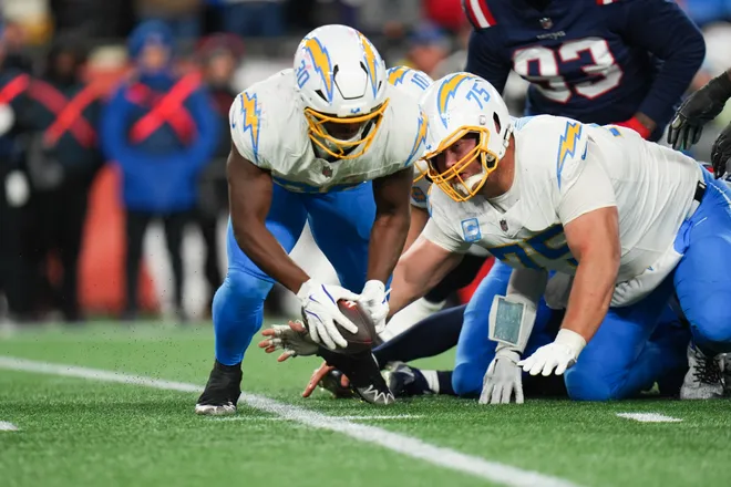 Jan 11, 2026; Foxborough, MA, USA; Los Angeles Chargers running back Kimani Vidal (30) recovers a fumble from Los Angeles Chargers quarterback Justin Herbert (10) during the third quarter against the New England Patriotsin an AFC Wild Card Round game at Gillette Stadium. Mandatory Credit: David Butler II-Imagn Images