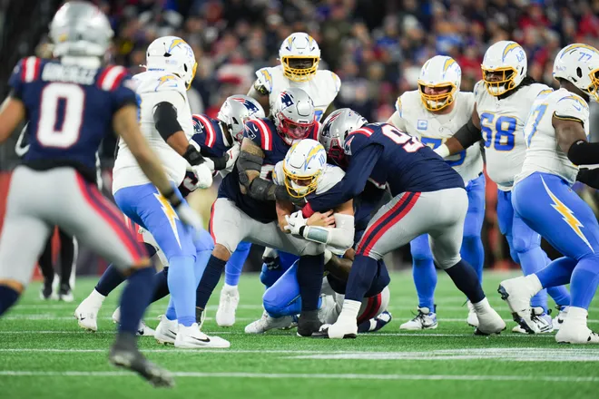 Jan 11, 2026; Foxborough, MA, USA; Los Angeles Chargers quarterback Justin Herbert (10) is sacked during the fourth quarter against the New England Patriots in an AFC Wild Card Round game at Gillette Stadium. Mandatory Credit: David Butler II-Imagn Images