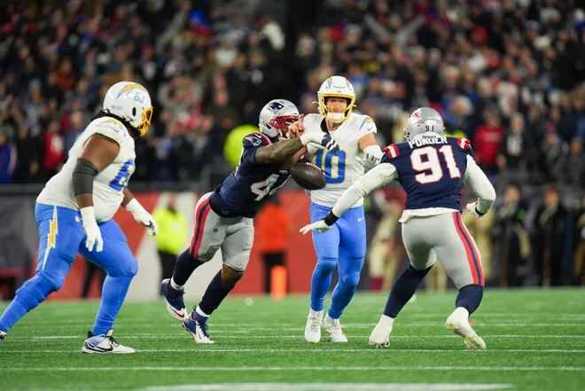 Jan 11, 2026; Foxborough, MA, USA; New England Patriots linebacker K'lavon Chaisson (44) forces a fumble from Los Angeles Chargers quarterback Justin Herbert (10) during the fourth quarter in an AFC Wild Card Round game at Gillette Stadium. Mandatory Credit: David Butler II-Imagn Images