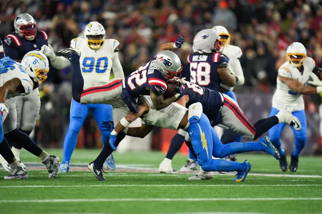 Jan 11, 2026; Foxborough, MA, USA; New England Patriots running back Treveyon Henderson (32) rushes and is tackled by Los Angeles Chargers linebacker Daiyan Henley (0) during the fourth quarter in an AFC Wild Card Round game at Gillette Stadium. Mandatory Credit: David Butler II-Imagn Images