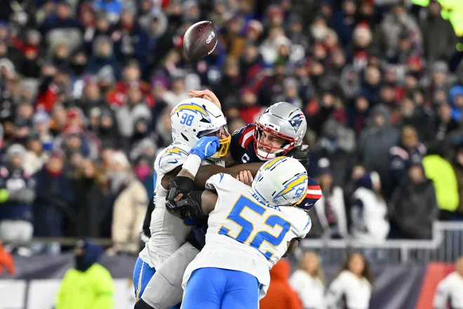 Jan 11, 2026; Foxborough, MA, USA; Los Angeles Chargers linebacker Odafe Oweh (98) and Los Angeles Chargers linebacker Khalil Mack (52) tackle New England Patriots quarterback Drake Maye (10) as he throws a pass during the second half in an AFC Wild Card Round game at Gillette Stadium. Mandatory Credit: Eric Canha-Imagn Images