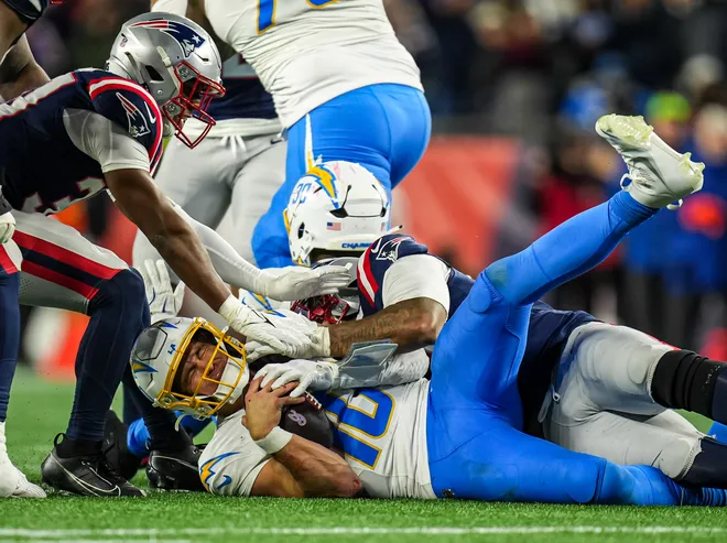 Jan 11, 2026; Foxborough, MA, USA; New England Patriots linebacker Anfernee Jennings (33) takes down Los Angeles Chargers quarterback Justin Herbert (10) during the second half in an AFC Wild Card Round game at Gillette Stadium. Mandatory Credit: David Butler II-Imagn Images