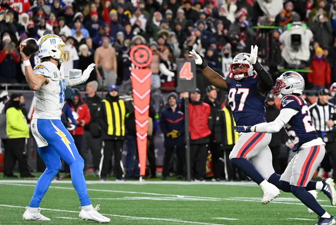 Jan 11, 2026; Foxborough, MA, USA; New England Patriots defensive end Milton Williams (97) tries to break-up a pass by Los Angeles Chargers quarterback Justin Herbert (10) during the second half in an AFC Wild Card Round game at Gillette Stadium. Mandatory Credit: Eric Canha-Imagn Images