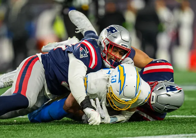 Jan 11, 2026; Foxborough, MA, USA; New England Patriots linebacker Elijah Ponder (91) and linebacker Christian Elliss (53) take down Los Angeles Chargers quarterback Justin Herbert (10) during the second half in an AFC Wild Card Round game at Gillette Stadium. Mandatory Credit: David Butler II-Imagn Images