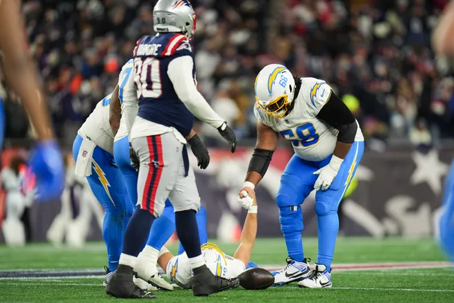 Jan 11, 2026; Foxborough, MA, USA; Los Angeles Chargers guard Jamaree Salyer (68) helps Los Angeles Chargers quarterback Justin Herbert (10) to his feet after a sack during the fourth quarter in an AFC Wild Card Round game at Gillette Stadium. Mandatory Credit: David Butler II-Imagn Images