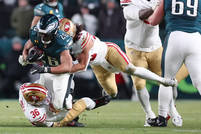 Jan 11, 2026; Philadelphia, PA, USA; San Francisco 49ers safety Marques Sigle (36) and linebacker Eric Kendricks (43) tackle Philadelphia Eagles running back Saquon Barkley (26) during the second quarter in an NFC Wild Card Round game at Lincoln Financial Field. Mandatory Credit: Bill Streicher-Imagn Images