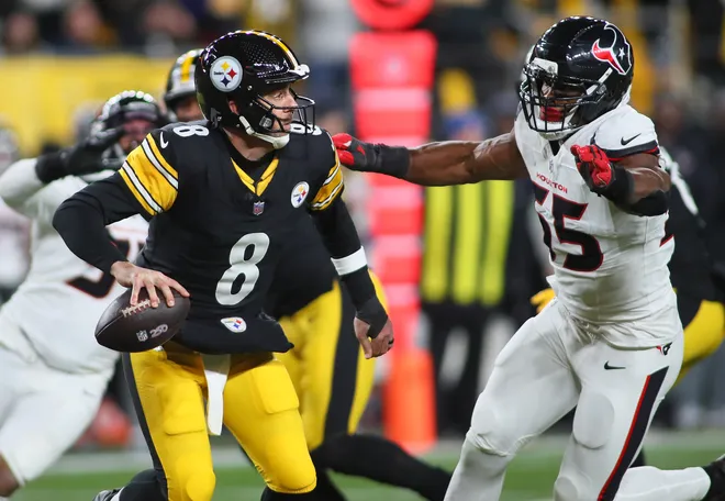 Pittsburgh Steelers quarterback Aaron Rodgers (8) scatters out of the pocket while being pressured by Houston Texans defensive end Danielle Hunter (55) during the first half of the NFL Wild Card game at Acrisure Stadium in Pittsburgh, PA on January 12, 2026.