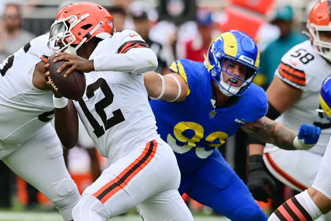 Aug 23, 2025; Cleveland, Ohio, USA; Los Angeles Rams defensive tackle Jack Heflin (93) grabs the jersey of Cleveland Browns quarterback Shedeur Sanders (12) during the second half at Huntington Bank Field. Mandatory Credit: Ken Blaze-Imagn Images