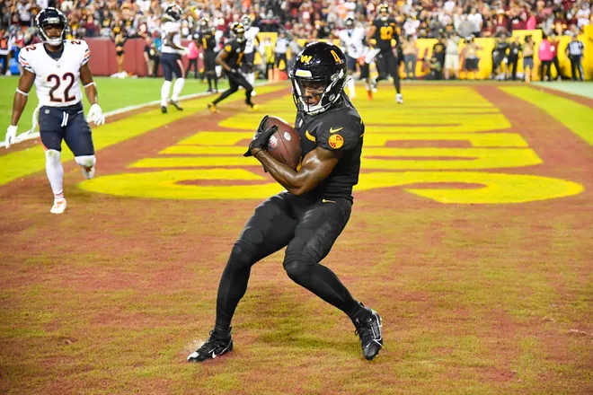 Oct 5, 2023; Landover, Maryland, USA; Washington Commanders wide receiver Curtis Samuel (4) scores a touchdown against the Chicago Bears during the second half at FedExField. Mandatory Credit: Brad Mills-USA TODAY Sports