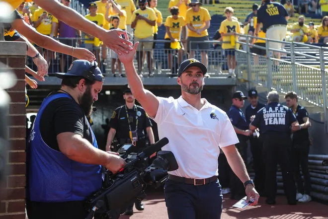 Michigan interim head coach Jesse Minter high-fives fans during warm up before the East Carolina game at Michigan Stadium in Ann Arbor, Saturday, Sept. 2, 2023.