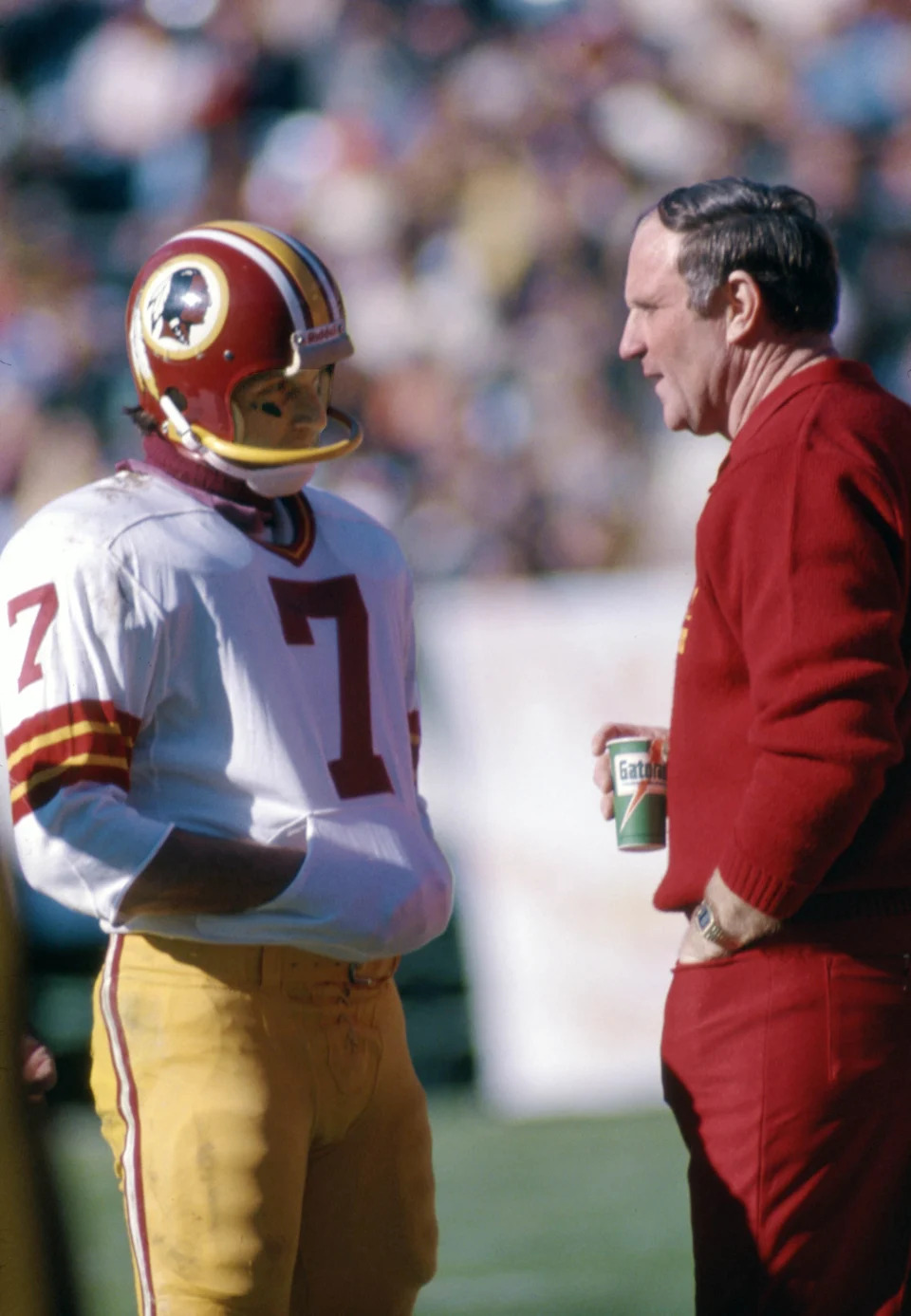 Washington quarterback Joe Theismann talks with head coach Jack Pardee on the sideline against the Atlanta Falcons at Fulton County Stadium.