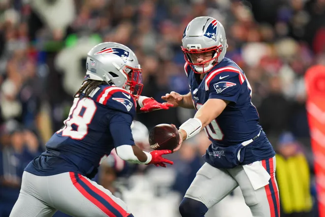 Jan 11, 2026; Foxborough, MA, USA; New England Patriots quarterback Drake Maye (10) hands the ball off to New England Patriots running back Rhamondre Stevenson (38) during the first quarter against the Los Angeles Chargers in an AFC Wild Card Round game at Gillette Stadium. Mandatory Credit: David Butler II-Imagn Images