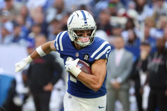 Oct 12, 2025; Indianapolis, Indiana, USA; Indianapolis Colts wide receiver Alec Pierce (14) carries the ball against the Arizona Cardinals during the fourth quarter of the game at Lucas Oil Stadium. Mandatory Credit: Trevor Ruszkowski-Imagn Images