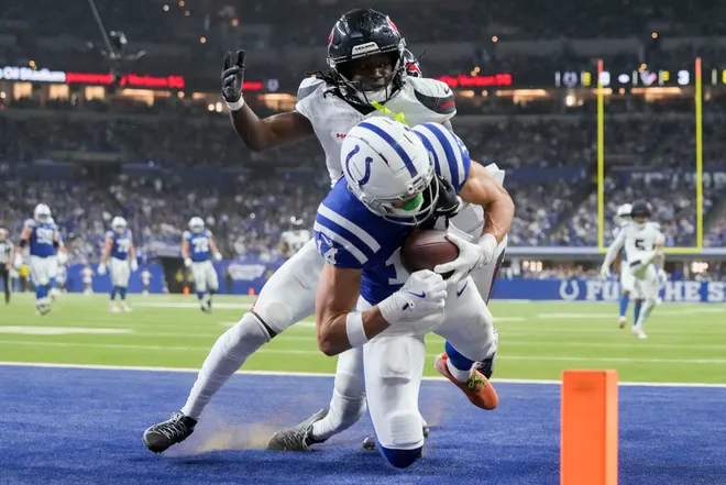 Nov 30, 2025; Indianapolis, Indiana, USA; Indianapolis Colts wide receiver Alec Pierce (14) makes a catch in front of Houston Texans cornerback Kamari Lassiter (4) for a touchdown during a game at Lucas Oil Stadium. Mandatory Credit: Grace Hollars-USA TODAY Network via Imagn Images